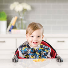 Boy sitting at table wearing Batman Bib