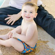 Boy in Superman Swim Diaper sitting poolside